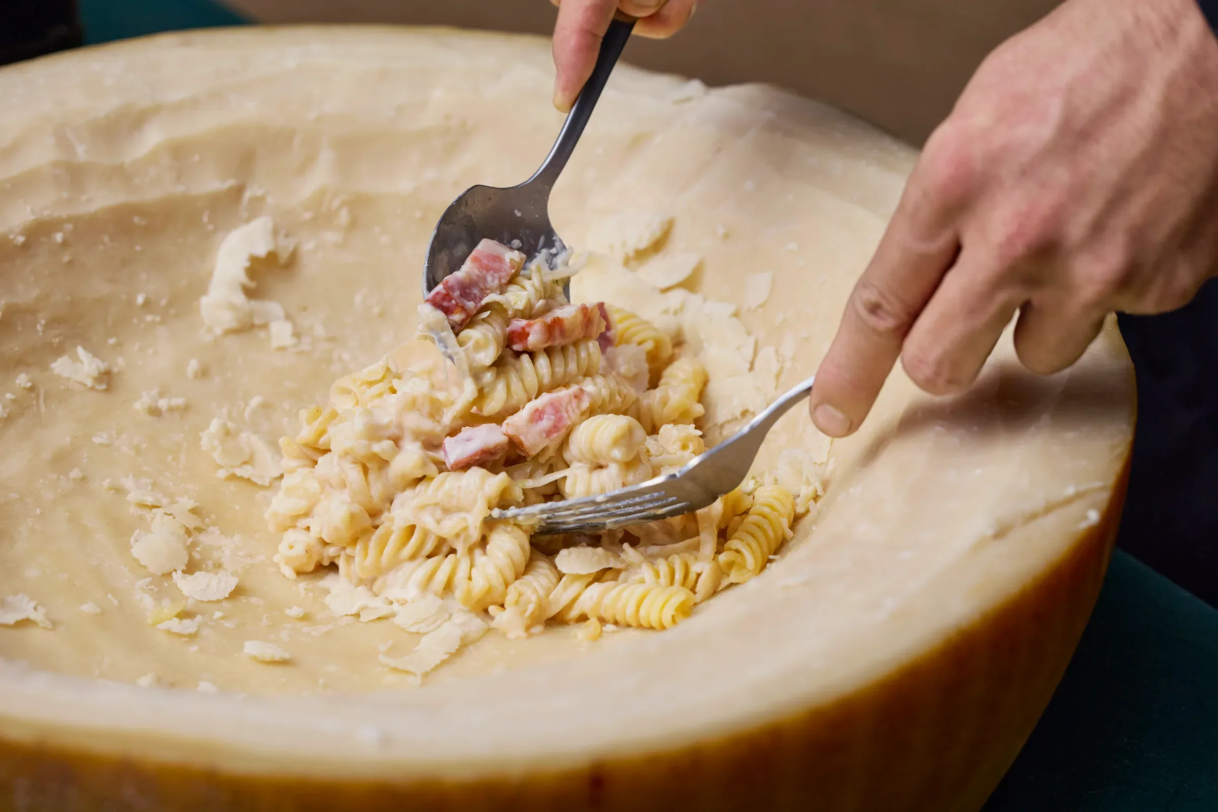 ホールチーズの上で仕上げるパスタ